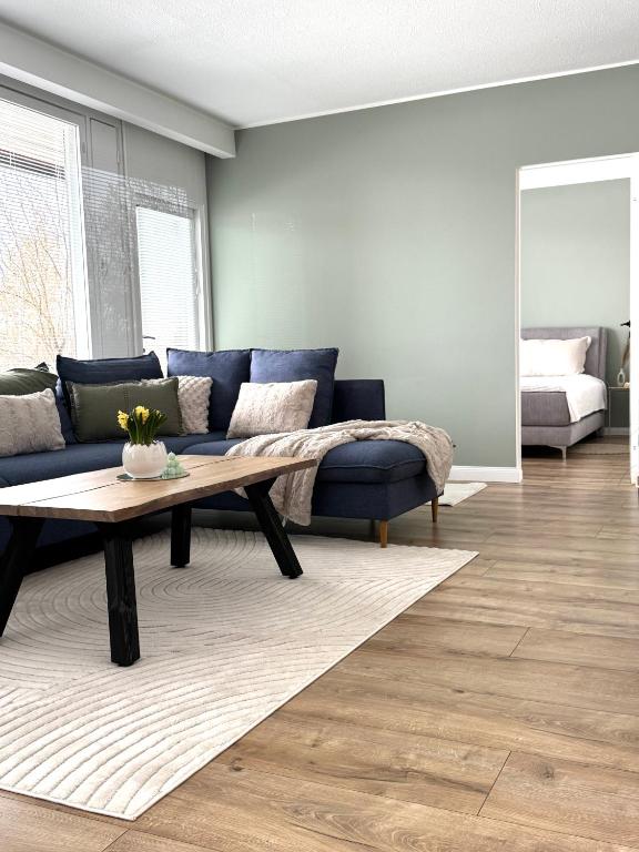 a living room with a blue couch and a coffee table at Tullikatu Two-Bedroom Apartment in Kristinestad