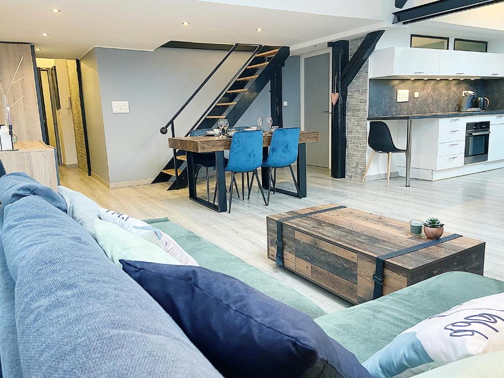 a living room with a blue couch and a table at Le Sweet Home, clim, parking privé, wifi in Reims