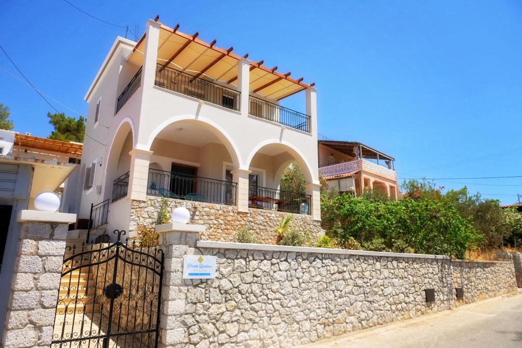 a white house on a stone wall at Maria's Private Residence in Kalymnos