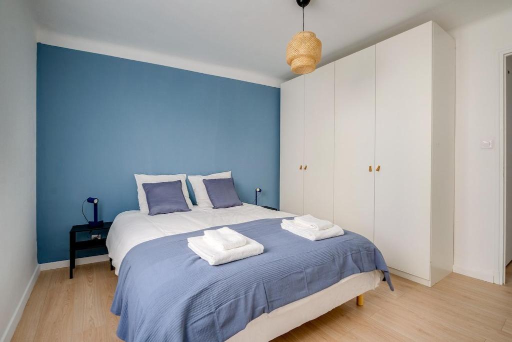 - une chambre bleue avec un lit et des serviettes dans l'établissement L'éclat des 5 Avenues, à Marseille