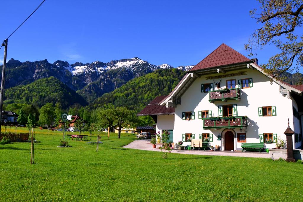 a large white house with mountains in the background at Kerschbaumergut in Grossgmain