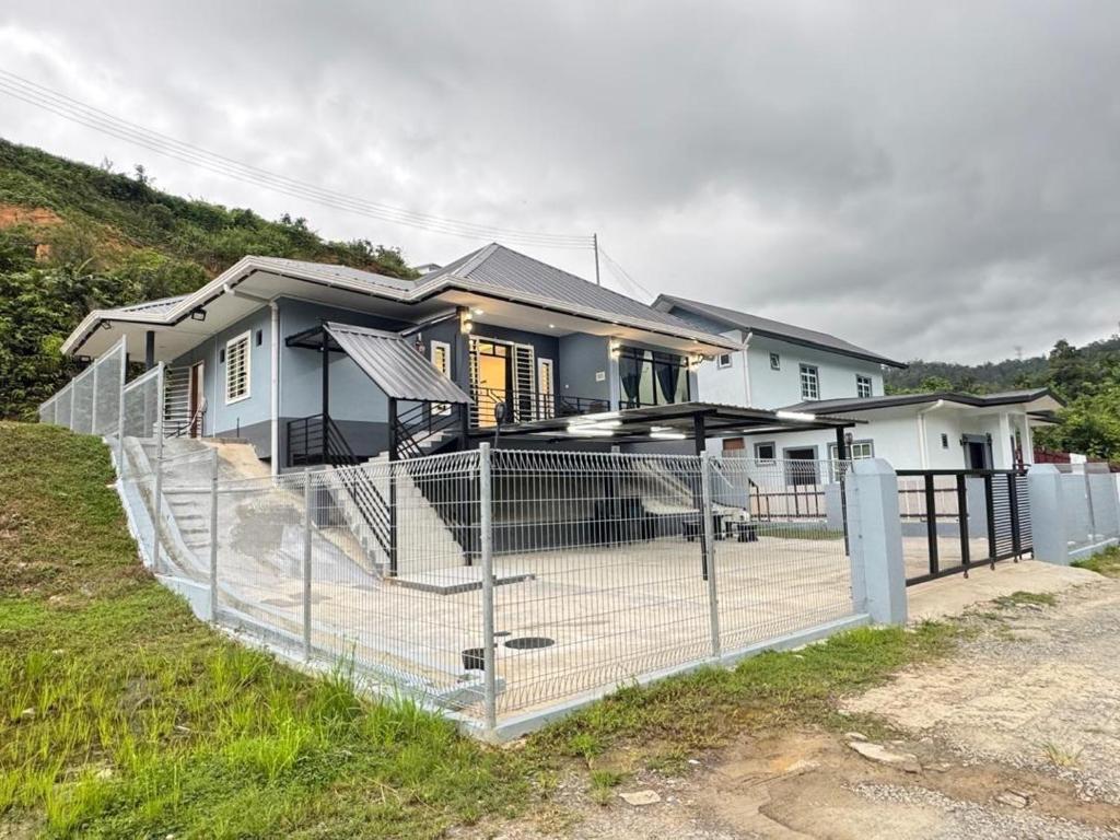 a house with a fence in front of it at Vinzsugudhomestay in Penampang