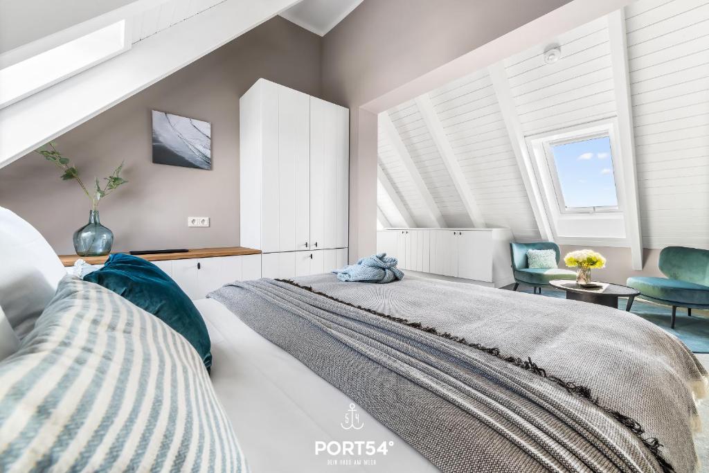 a bedroom with a large bed and two chairs at Ferienwohung Genießen St Peter-Ording in Böhl