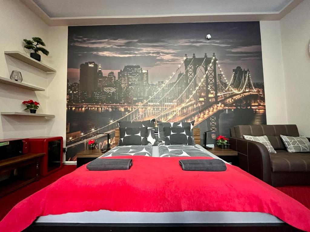 a bedroom with a large red bed with a city skyline at JohnGold Red Room in Debrecen