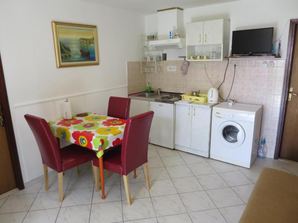 a kitchen with a table and chairs and a washing machine at Rooms Ljubo in Dubrovnik