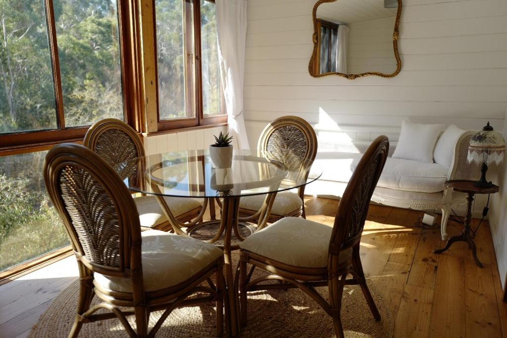 ein Esszimmer mit Glastisch und Stühlen in der Unterkunft Charming Historical Cottage in Bridgewater in Bridgewater