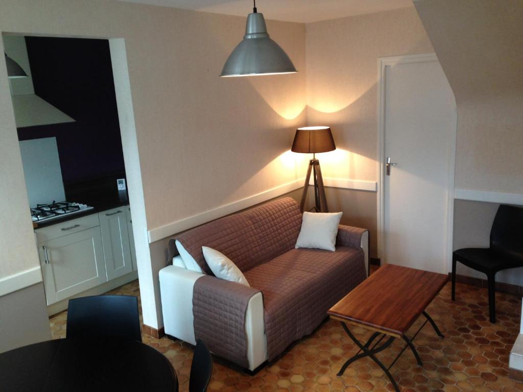 a living room with a couch and a table at Les Coquillages in Trégastel