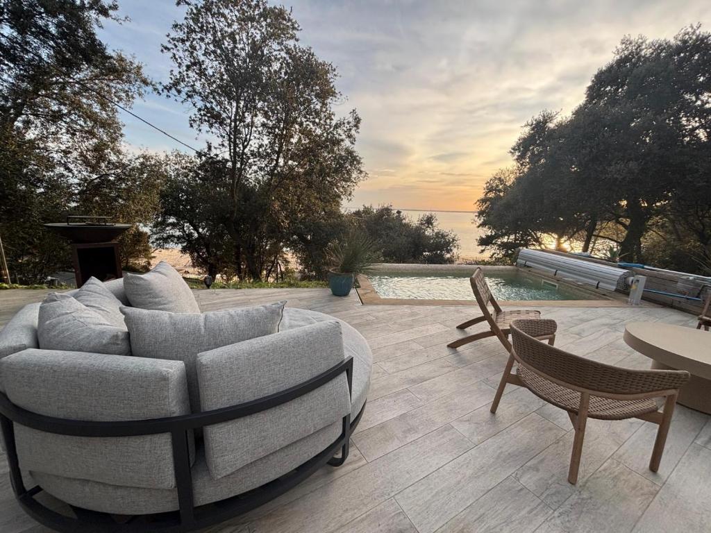 - un canapé et deux chaises assises sur une terrasse dans l'établissement Villa ILO - devant la plage des Nonnes, à Meschers-sur-Gironde