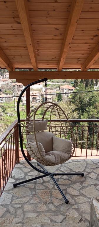 a wicker chair sitting on a porch at family home in Dimitsana
