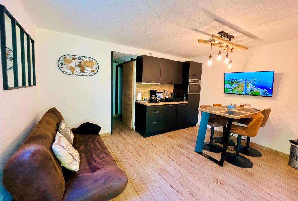 un salon avec un canapé et une table dans l'établissement Appartement à 100m de la plage et Thalasso, à Concarneau