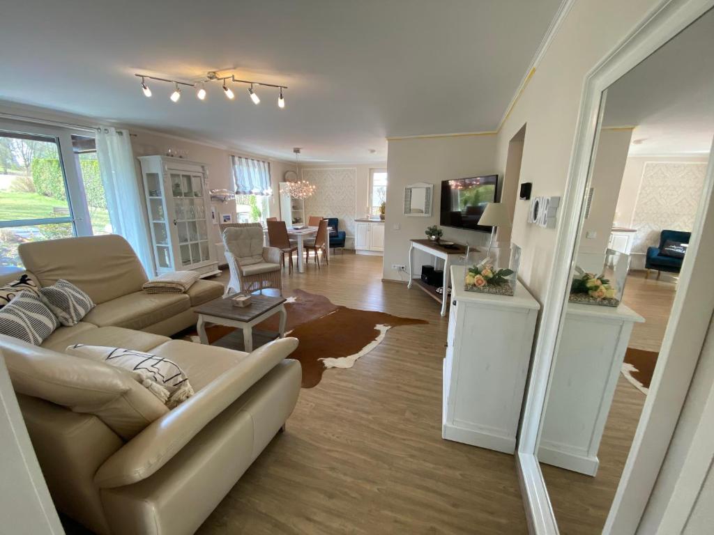 a living room with a couch and a dining room at Schöne Wohnung im Landhausstil nahe Olpe Biggesee in Olpe