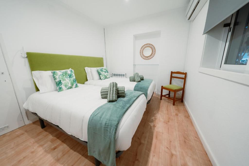 a bedroom with two beds and a chair at Douro Garden - Authentic Portuguese Guesthouse in Vila Nova de Gaia