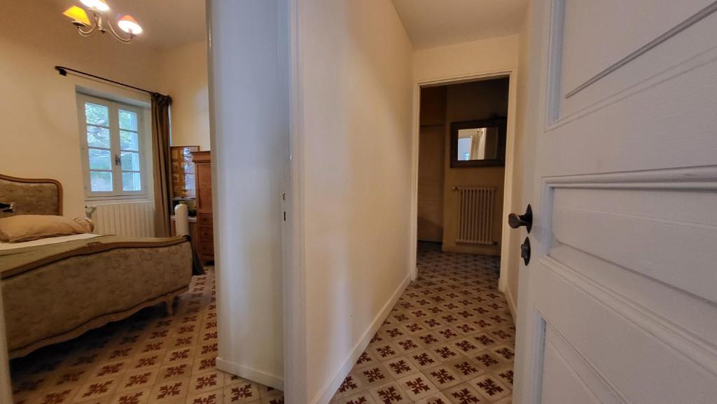 - un couloir avec une porte menant à une chambre avec un lit dans l'établissement Comme à la campagne en plein cœur de village, à Fontvieille