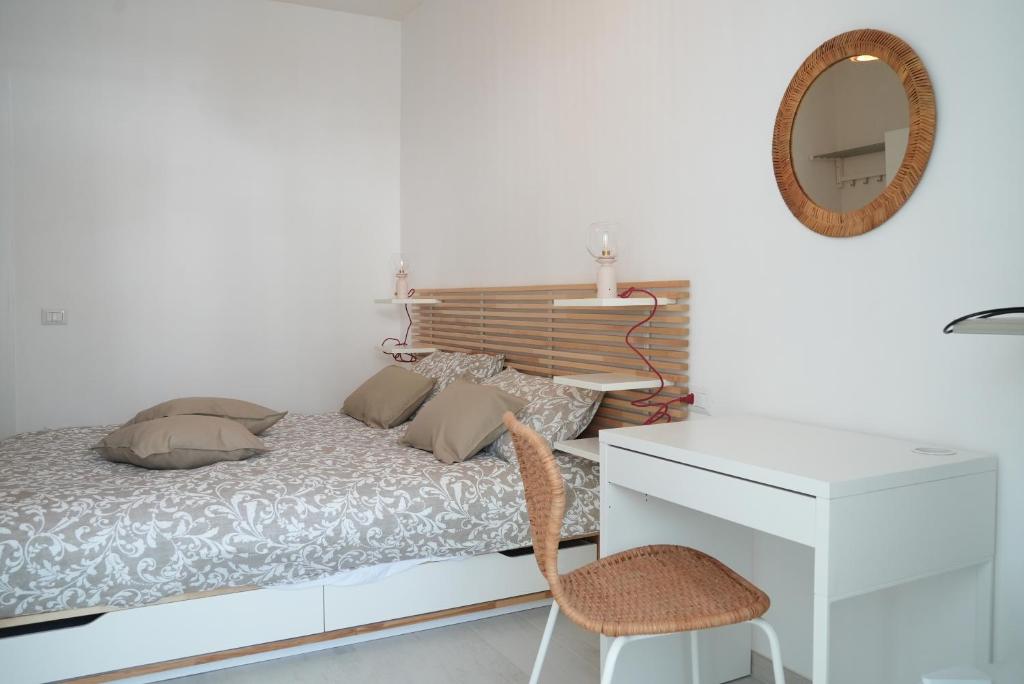 Park Room - Ischia Centro في ايسكيا: غرفة نوم بسرير ومرآة وكرسي