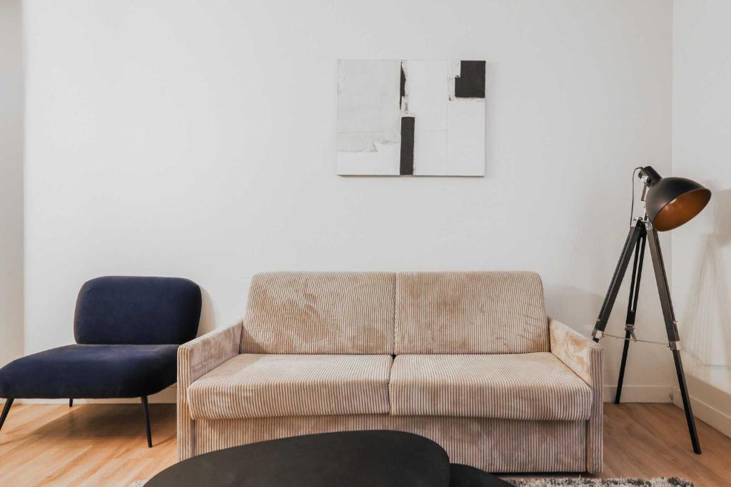 un salon avec un canapé et une chaise dans l'établissement Modern Apartment 1BR- 4P Le Marais Quarter, à Paris