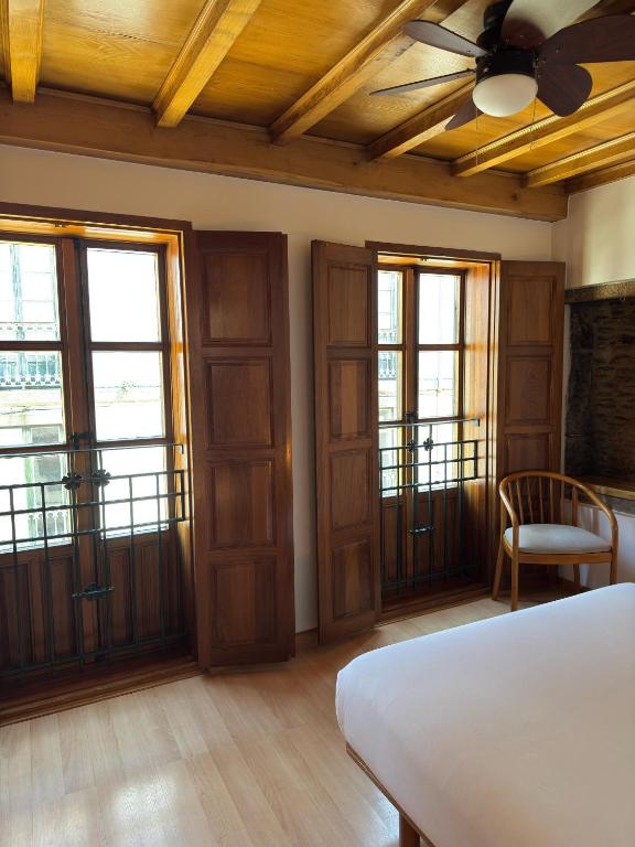 a bedroom with a bed and a ceiling fan at Apartamentos Campanas de San Juan in Santiago de Compostela