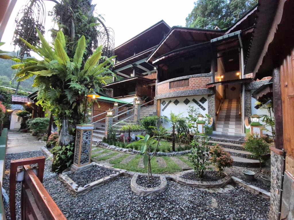 a house with a garden in front of it at Sam's Bungalows And Treks in Bukit Lawang