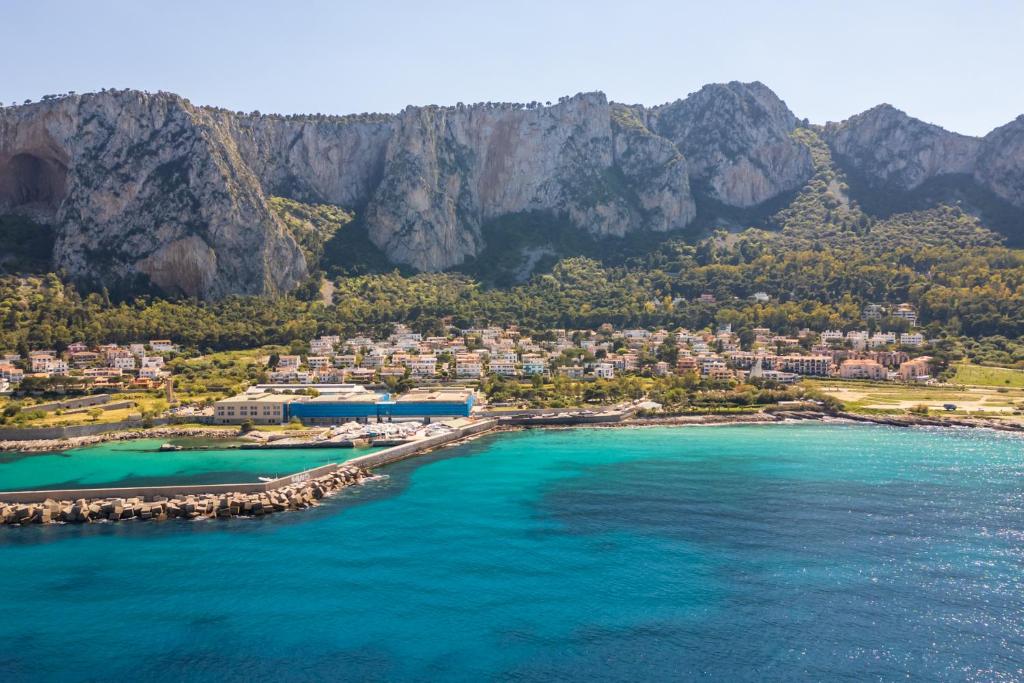 una vista aerea di una spiaggia con montagne sullo sfondo di A pochi passi dal mare a Mondello