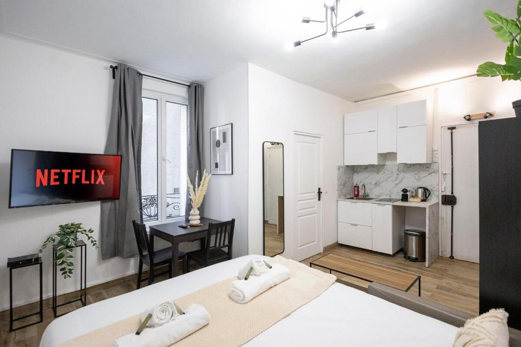 une chambre avec un lit et une cuisine avec une table dans l'établissement Studio à 2 min métro 13 - accès Paris Champs-Élysées, à Asnières-sur-Seine