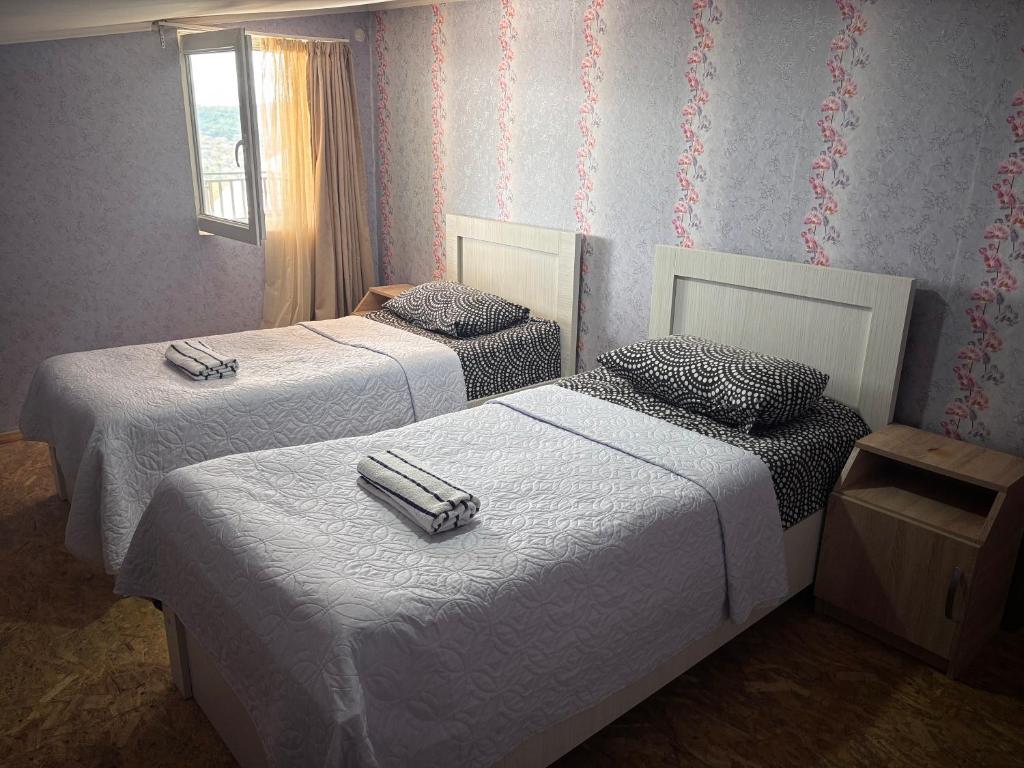a bedroom with two beds and a window at Guest house Katerina in Kutaisi
