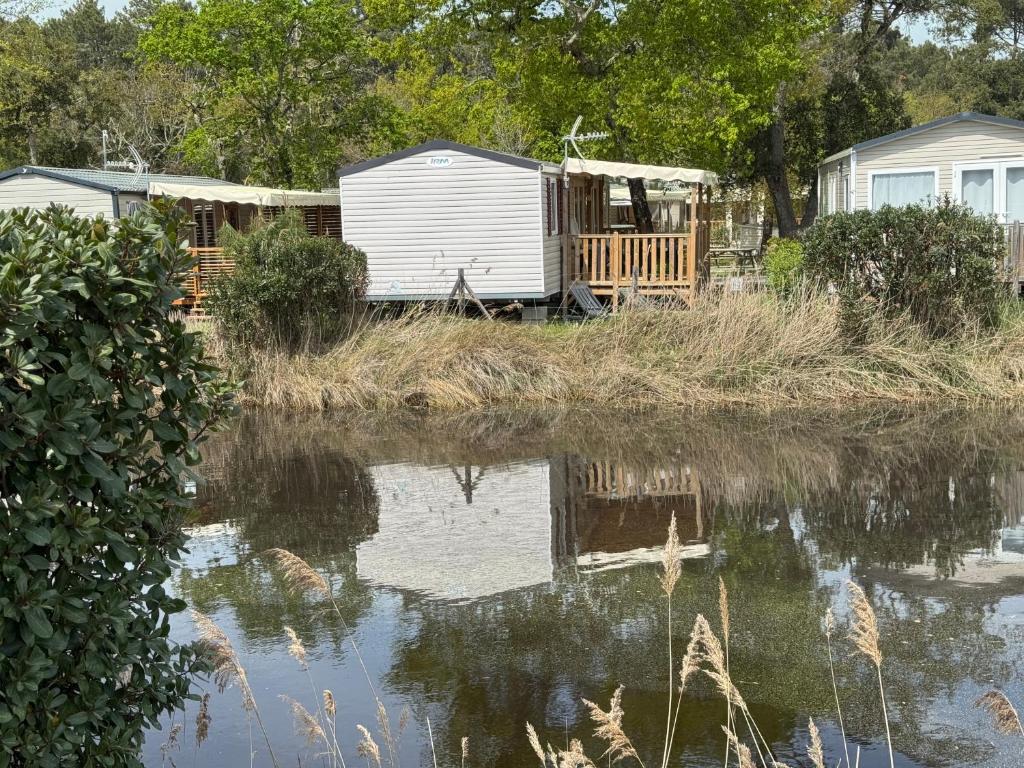- deux mobile homes à côté d'une masse d'eau dans l'établissement Bungalow moderne vue bassin les viviers Cap-ferret, à Lège-Cap-Ferret