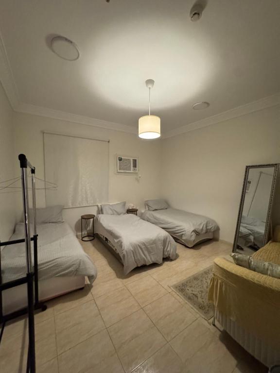 a bedroom with two beds and a mirror on the wall at شقة أنيقة بالزاهر غرفتين وصالة in Makkah