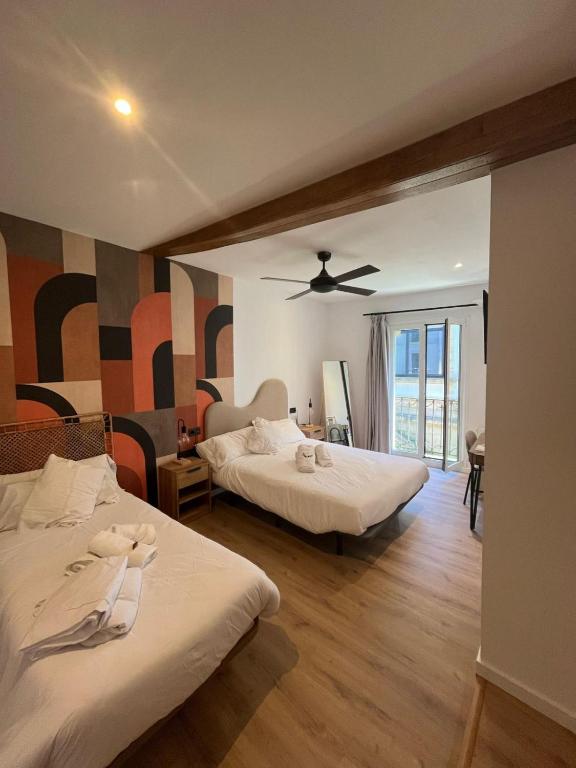 サン・セバスティアンにあるKaixo Roomsのベッド2台と天井ファン付きの寝室