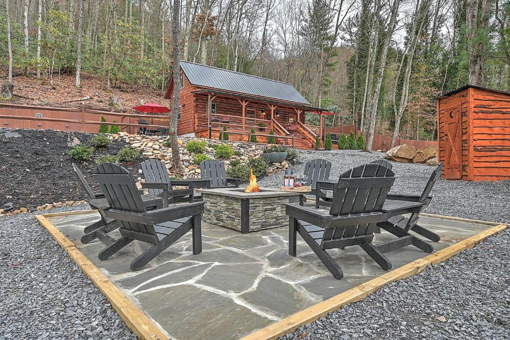 three chairs and a fire pit with a log cabin at Luxury in the Smokey Mountains Pet Friendly with Hot Tub in Elizabethton
