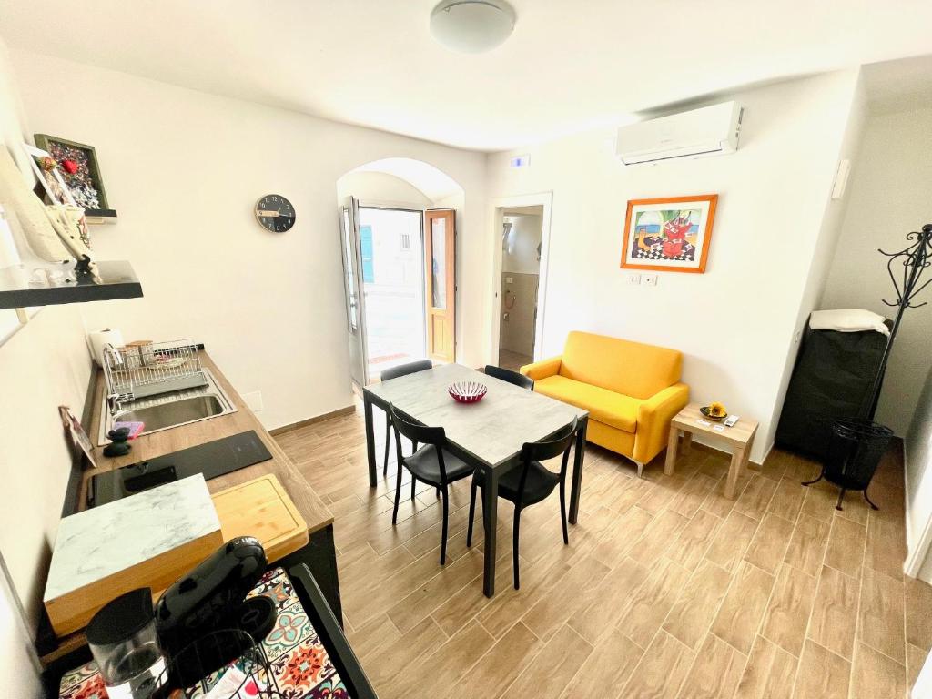 ein Wohnzimmer mit einem Tisch und einem gelben Stuhl in der Unterkunft Santo Stefano 8 - Comfort & Relax in Matera