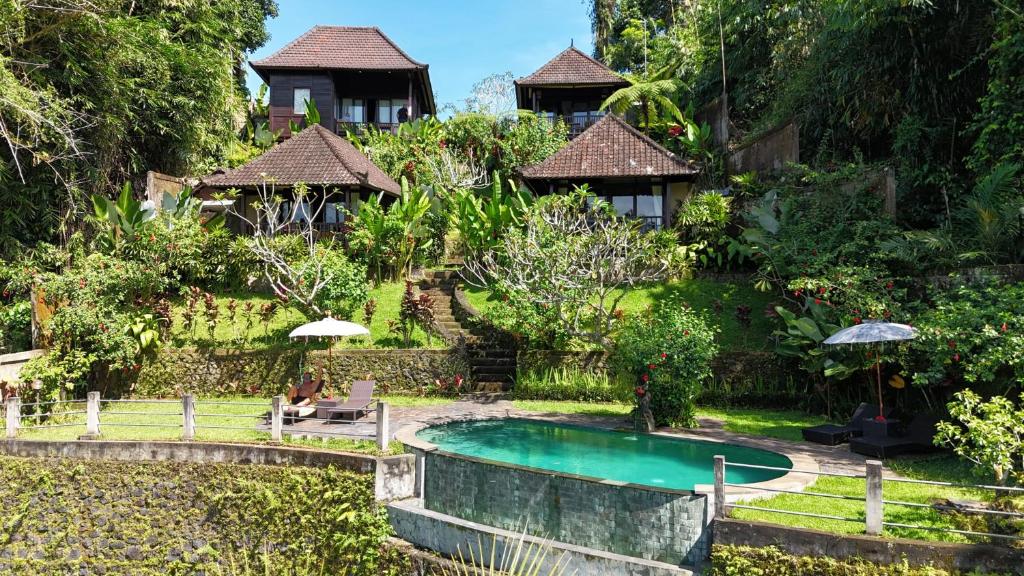 a resort with a swimming pool and a house at Villa Wedang in Tegalalang