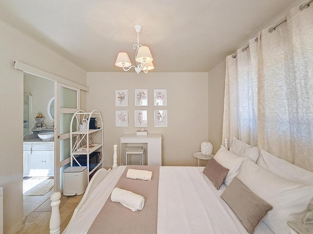 a bedroom with a large white bed and a window at Chambre d'Hôtes "Au Clos des Redonnets" avec Piscine in Saint-Cézaire-sur-Siagne