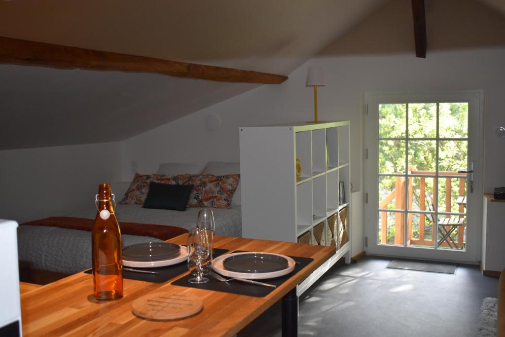 Cette chambre comprend une table avec des assiettes et des verres. dans l'établissement Le grenier des filles, à Les Alleuds