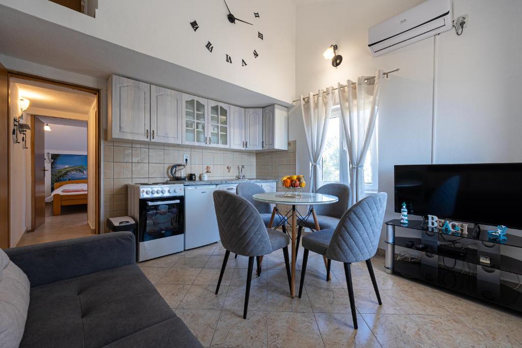 a kitchen and living room with a table and chairs at Apartments Ivo Bozinovic in Tivat
