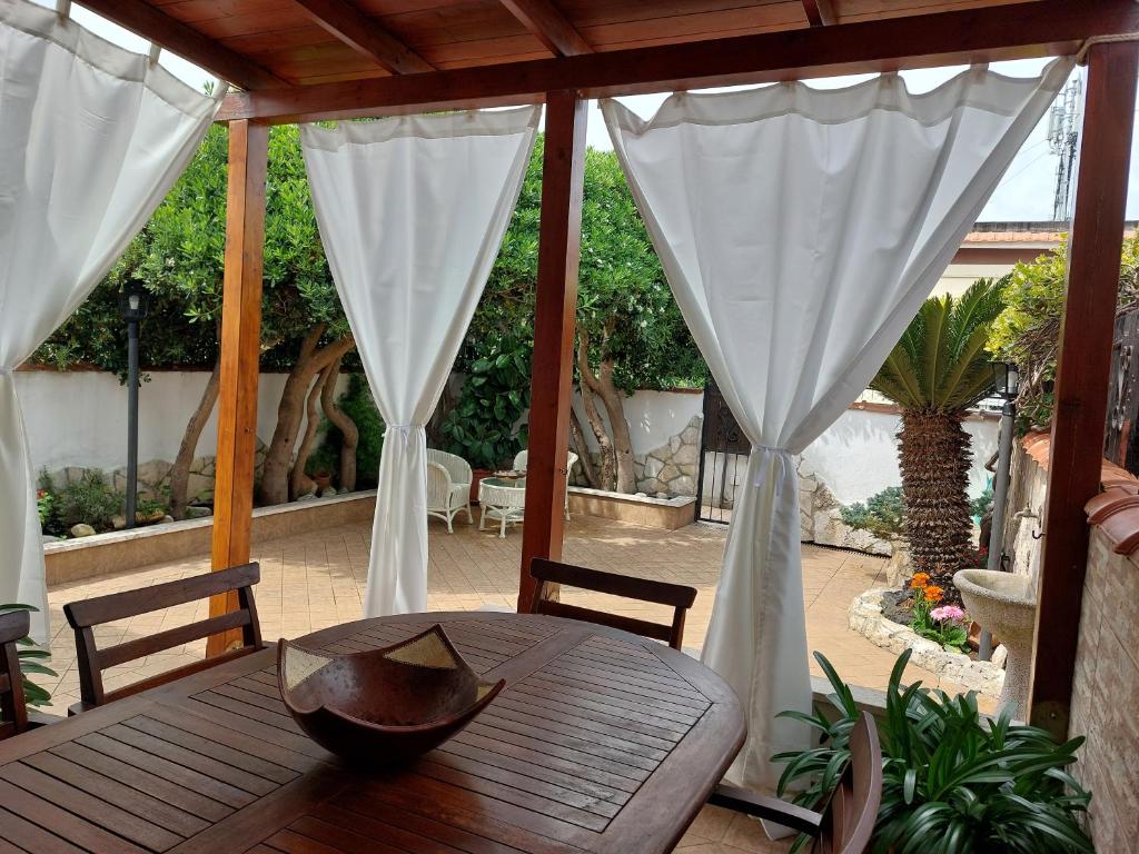 a wooden table with a bowl on top of a patio at La Cycas in Torvaianica