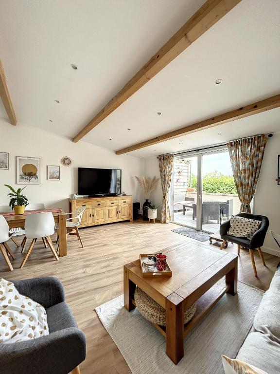 un salon avec un canapé et une table dans l'établissement Beau duplex et studio proche de la mer, à Donville-les-Bains