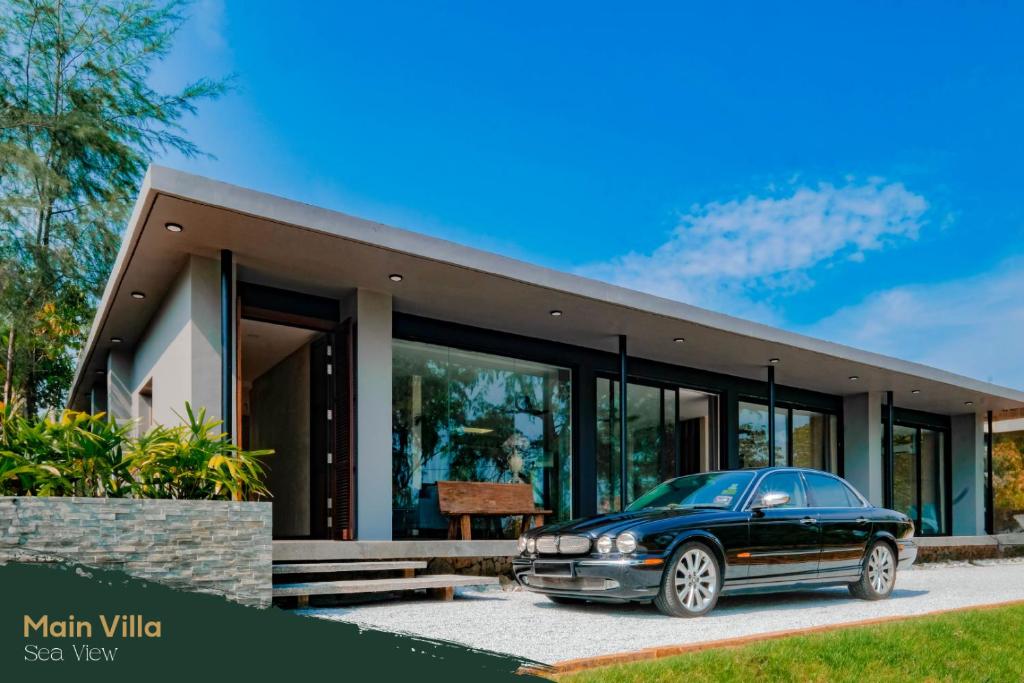 a car parked in front of a house at Katsetiu Villas in Kampong Telaga Papan