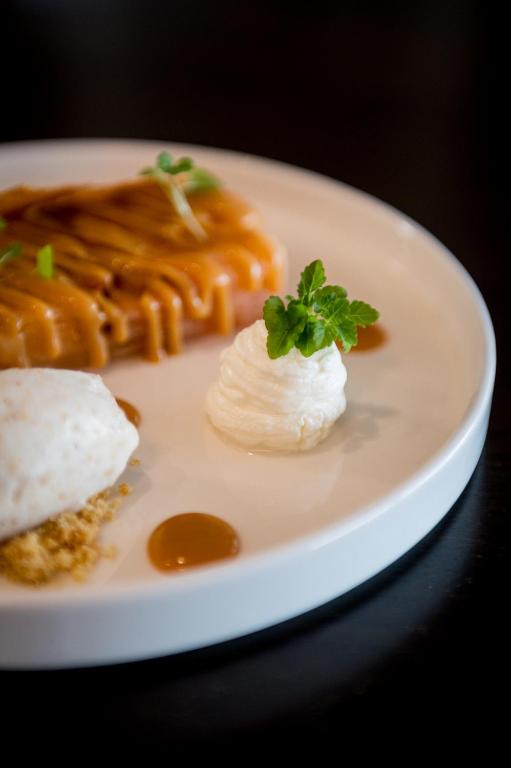 a white plate with some food on a table at Saint Aubin Logis Hôtel & Restaurant in Saint-Aubin-sur-Mer