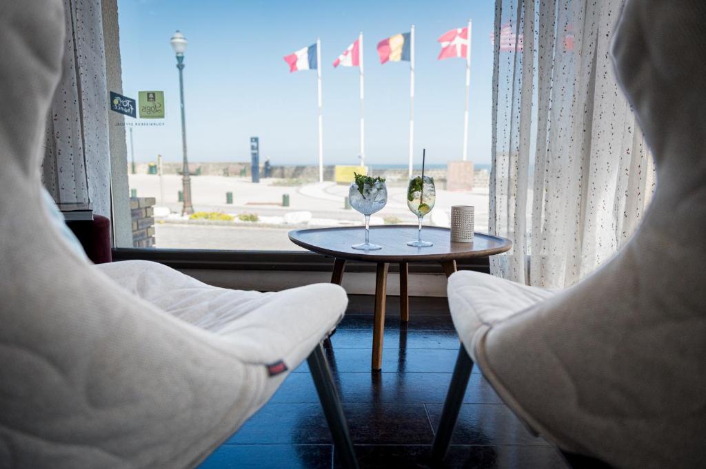 a room with two chairs and a table and a window at Saint Aubin Logis Hôtel & Restaurant in Saint-Aubin-sur-Mer
