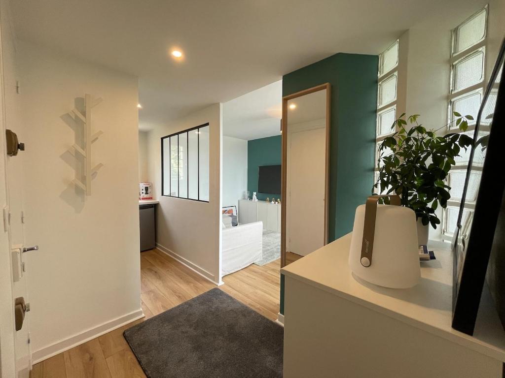 un salon avec une plante en pot sur un comptoir dans l'établissement Charmant appartement face à la mer, à Saint-Palais-sur-Mer