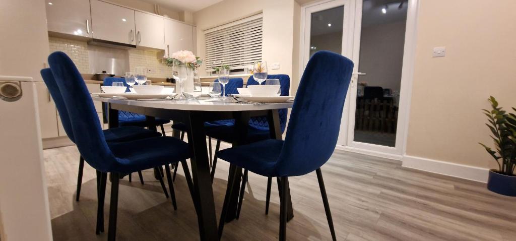 a dining room with a table and blue chairs at Spacious Colchester Home with Off-Street Parking for 4 cars in Colchester