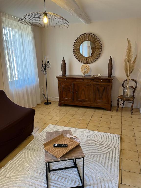 - un salon avec une table et un miroir dans l'établissement Le Luxembourg, à Narbonne