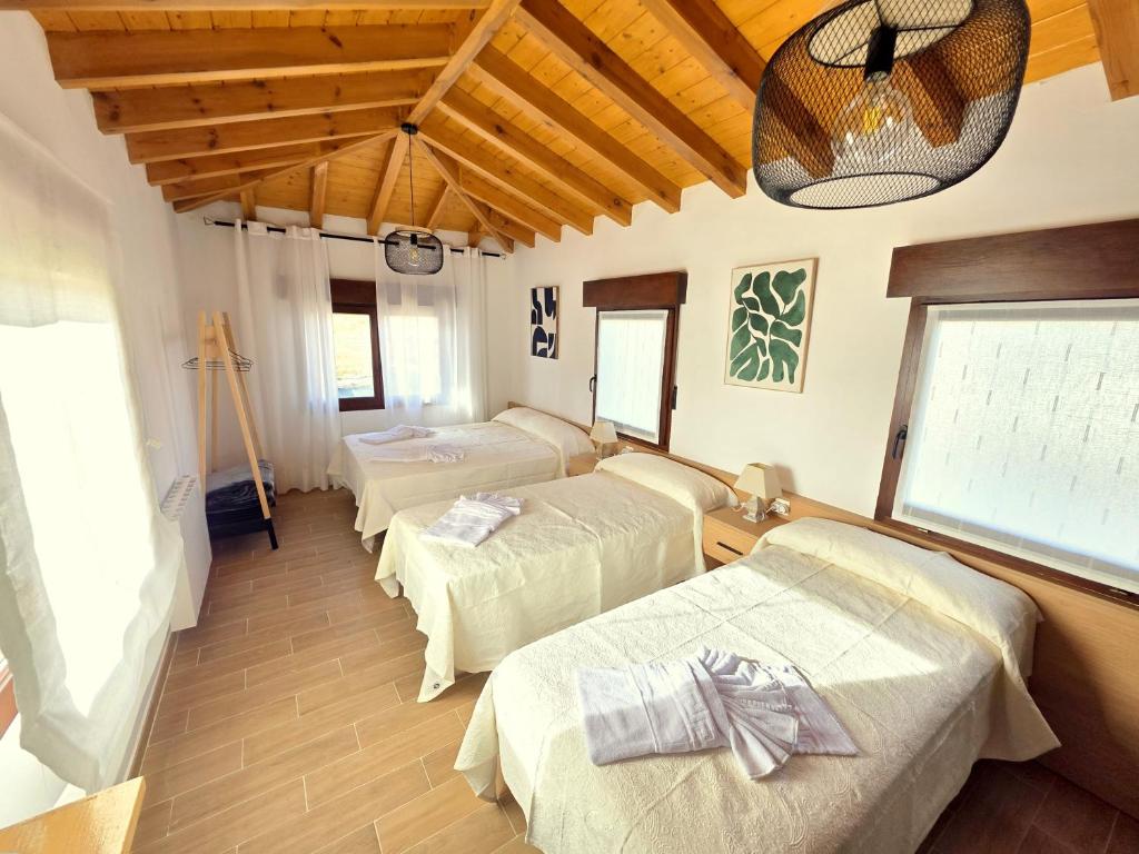 a room with three beds and a large window at Vivienda Camino de San Martin in Frómista