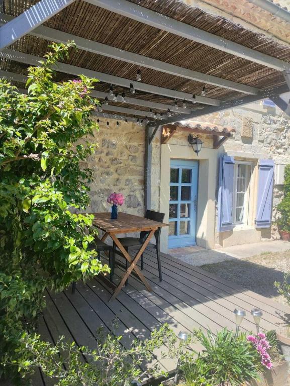 - une table de pique-nique en bois sur une terrasse en bois devant un bâtiment dans l'établissement Un Mas en Provence, à Boulbon