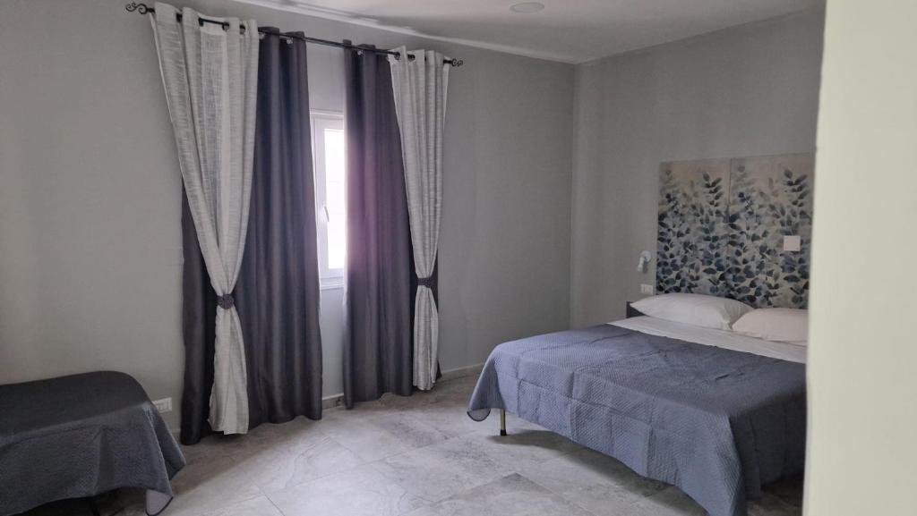un dormitorio con una cama y una ventana en Villa GEMMA, en Castel Volturno
