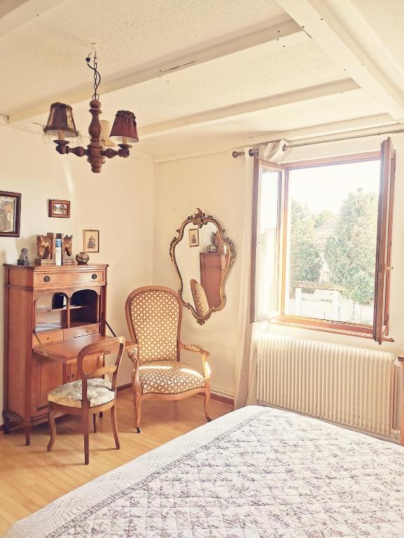 a bedroom with a bed and a desk and a chair at Maison LES 3 ROSES in Wolfisheim