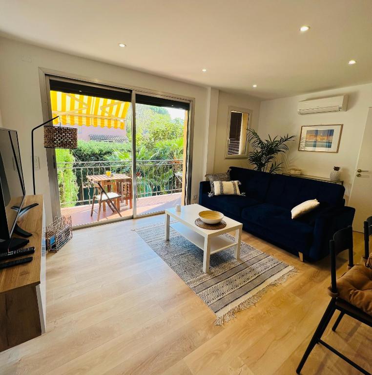 un salon avec un canapé bleu et une table dans l'établissement Superbe appartement terrasse et parking privé, à Saint-Tropez
