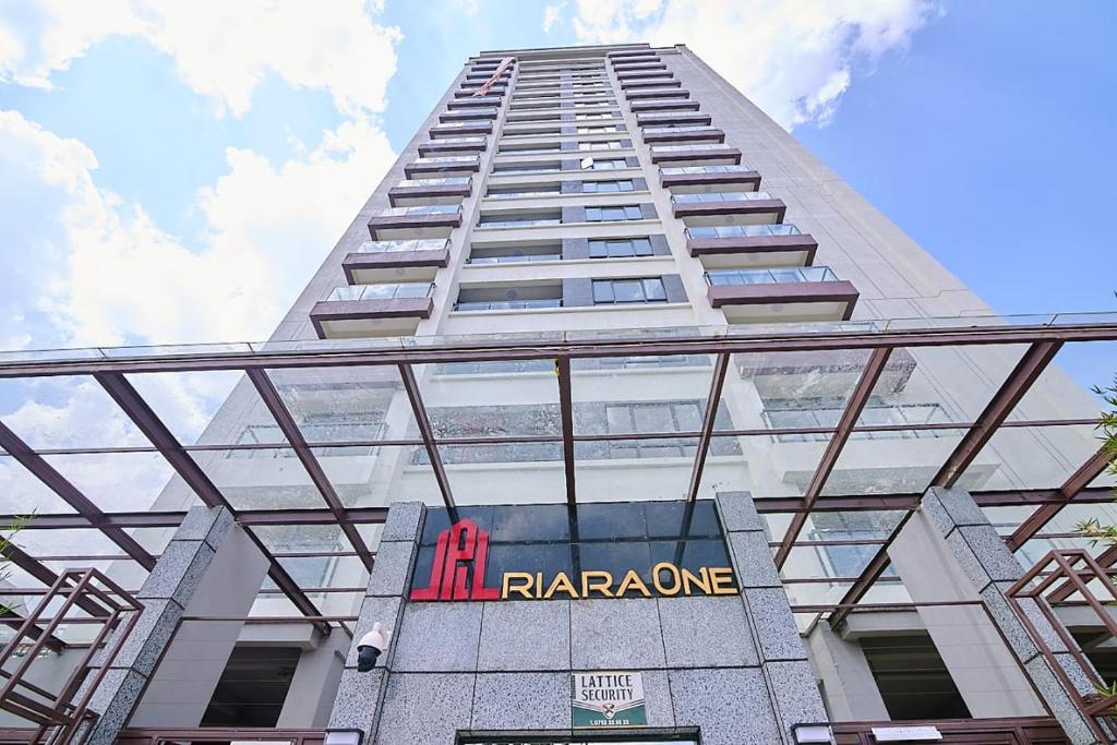 a tall white building with a pharmacy sign on it at Riara One Residency, Kilimani in Nairobi