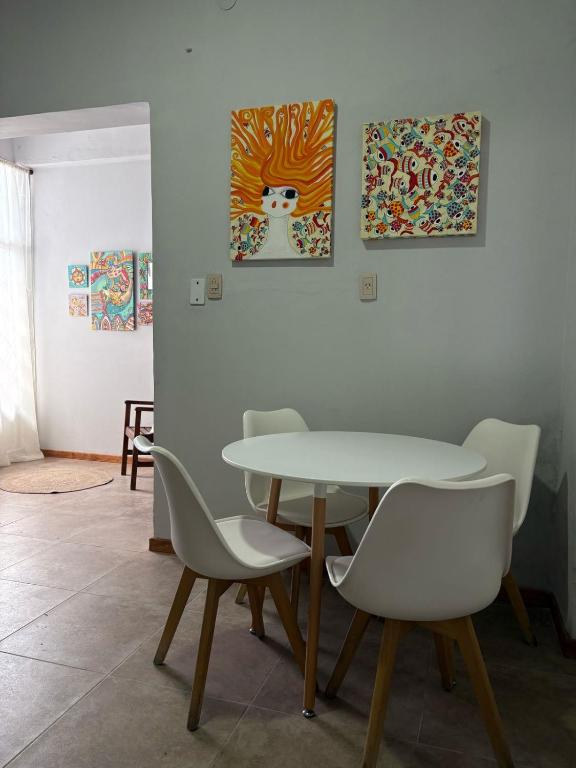a table and chairs in a room with paintings at Departamento en Catamarca capital in San Fernando del Valle de Catamarca