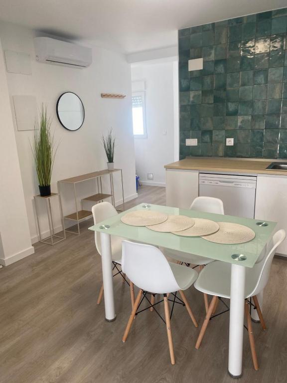 a dining room with a green table and white chairs at Pelayo Living in Castellón de la Plana