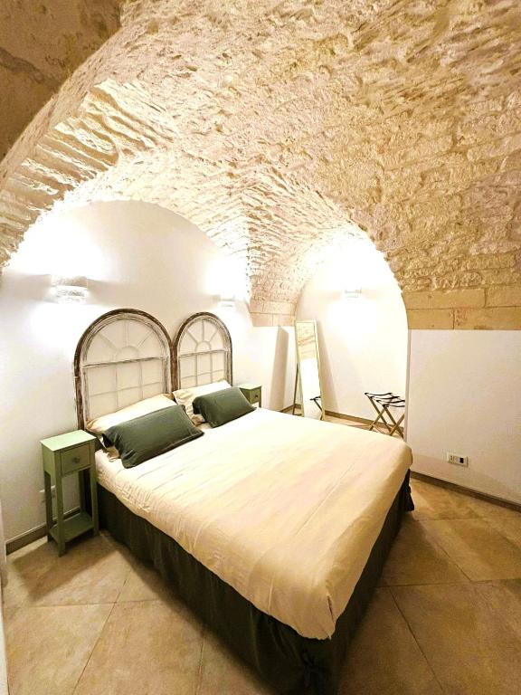 a bedroom with a large bed in a stone room at Dimora Fiore Guest House in Martina Franca
